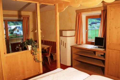 a bedroom with a desk with a computer and a table at Alfaierhof-Bergheimat in Gschnitz