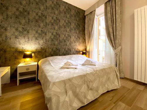 1 dormitorio con cama blanca y pared en Hotelier 51 en Roma