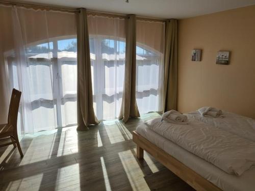 ein Schlafzimmer mit einem Bett und einem großen Fenster in der Unterkunft Der Landhof Weide in Stolpe auf Usedom