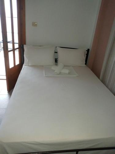 a large white bed with two pillows in a room at AGATHA appartments PALIOURIA in Kókkinon Nerón