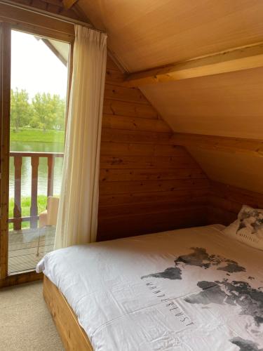 Posto letto in camera in legno con finestra. di Chalet La Meuse a Maaseik