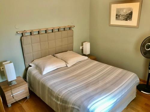 a bedroom with a large bed with two lamps on tables at Maison d'hôtes Côté Saône in Lyon