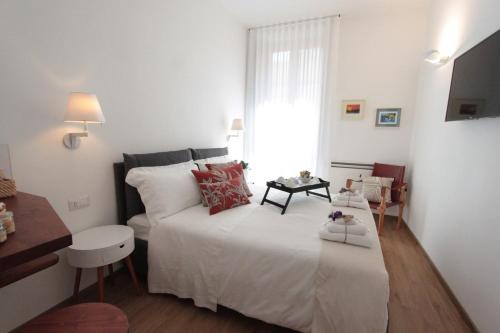 ein Schlafzimmer mit einem großen weißen Bett und einem Fenster in der Unterkunft Palazzo Pinto B&B - Brindisi (Italy) in Brindisi