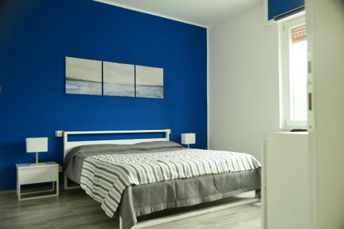 a blue bedroom with a bed and a blue wall at Le rose di Bino in Sestri Levante