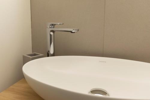 a white sink in a bathroom with a faucet at Palazzo dei Ciompi Suites in Florence