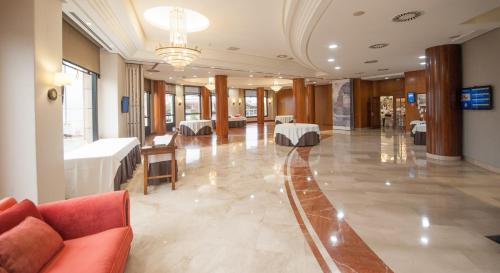 a lobby with a couch and tables in a building at Hotel Bahía in Santander
