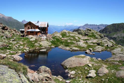 a house on top of a mountain with a pond at Alfaierhof-Bergheimat in Gschnitz