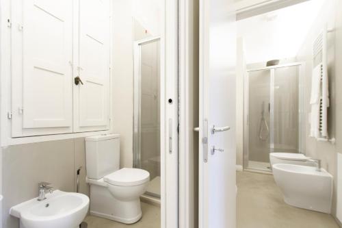 a white bathroom with a toilet and a sink at Palazzo dei Ciompi Suites in Florence
