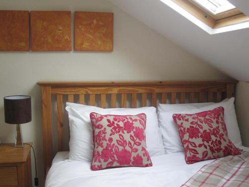 a bedroom with a bed with red and white pillows at Yeo Dale Hotel in Barnstaple