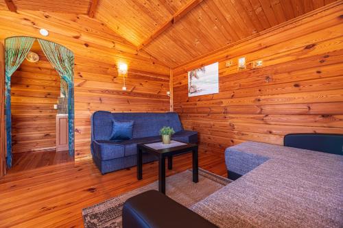a living room with a blue couch and a table at Žaliasis kampas Nameliai Šventojoje in Šventoji