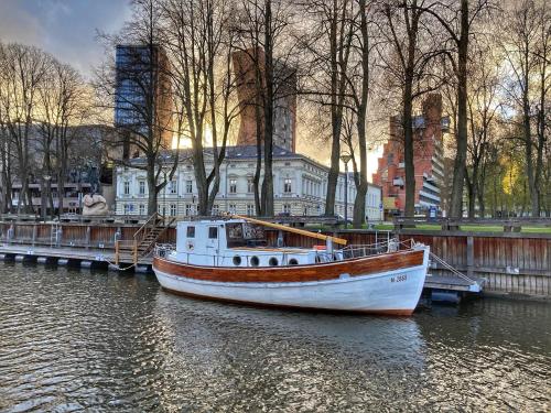 a boat is docked at a dock in the water at Historical boat Tu vėjo paklausk in Klaipėda