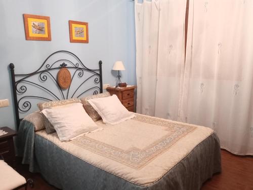 1 dormitorio con 1 cama con cabecero de hierro forjado en sol de membrillo, en Santo Tomé