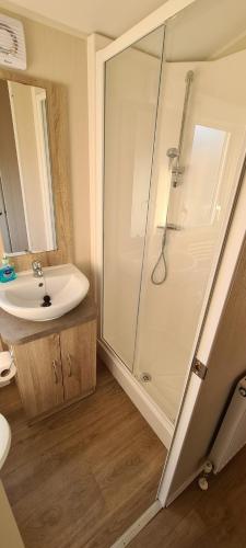 a bathroom with a white sink and a shower at The Shack - plot NB139 in Porth
