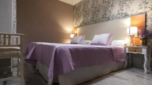 sypialnia z fioletowym łóżkiem i fioletowym kocem w obiekcie Alojamiento Rumfox w mieście Jaén