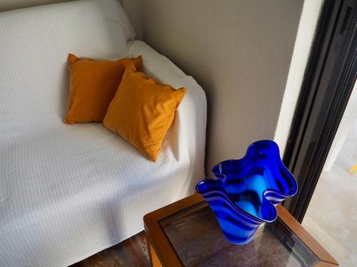 a blue vase on a table next to a couch at Hygge Retreat in Preveza