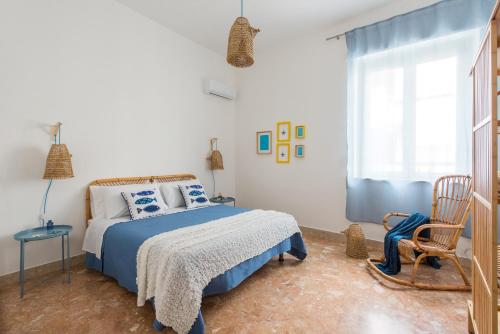 een slaapkamer met een blauw en wit bed en een raam bij Vento di Grecale - a pochi metri dal mare in Santa Flavia