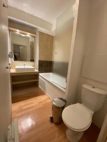 une salle de bain avec toilettes, lavabo et baignoire dans l'établissement Studio vue piste + parking souterrain privatif inclus, aux Orres