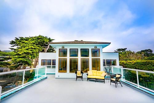 a large deck with chairs and a couch on a house at Luxury Beachfront Penthouse Walk to the Beach Restaurants Entertainment in Half Moon Bay