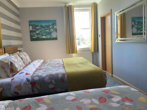 a bedroom with two beds and a window at Southbank Guesthouse in Elgin