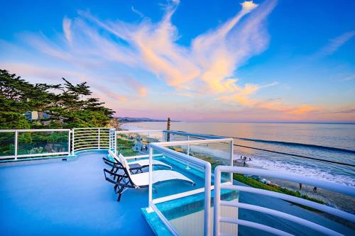 a balcony with two chairs and a view of the ocean at Luxury Beachfront Penthouse Walk to the Beach Restaurants Entertainment in Half Moon Bay