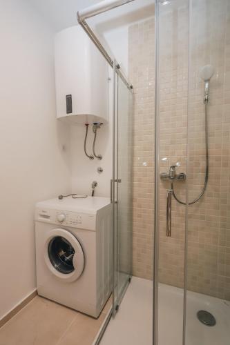 a washing machine in a bathroom with a shower at Status-M Аpartments 173 in Bečići
