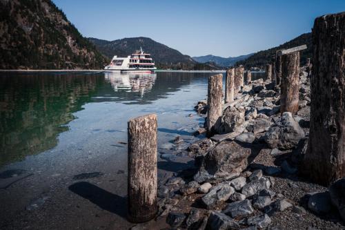 a boat in the water with some wooden poles at VIERKLEE - Das kinderfreundliche Ferienhaus am Achensee in Maurach