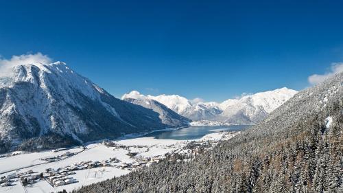 a view of a snowy mountain and a lake at VIERKLEE - Das kinderfreundliche Ferienhaus am Achensee in Maurach