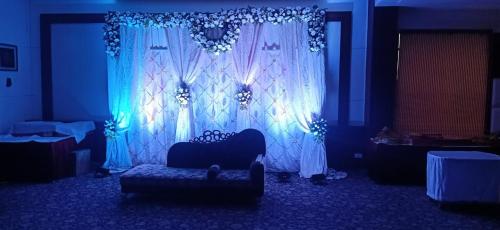 a blue room with a couch in front of a curtain at Comfort Inn Tulip Heights in Bathinda