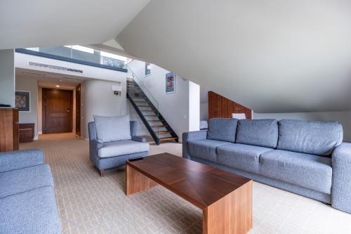 a living room with a couch and two chairs and a table at Natura Mazur Resort & Conference in Warchały