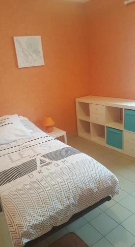 une chambre avec un lit et une commode dans l'établissement Gîte 3 places au cœur du Trégor, à Langoat