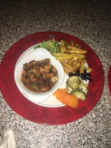 a plate of food with meat and vegetables and french fries at Hotel Restaurant Les Gorges de Chouvigny in Chouvigny