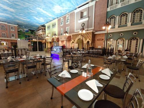 a restaurant with tables and chairs in a building at Regenta Inn Vadodara, 500m from Railway Station in Vadodara
