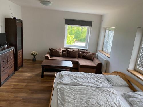 a bedroom with a bed and a couch and a window at Vinařský dům Kovárna in Březí