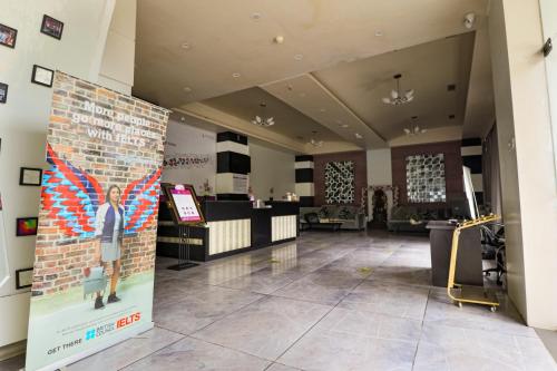a lobby with a wall with a poster of a woman at Regenta Inn Vadodara, 500m from Railway Station in Vadodara