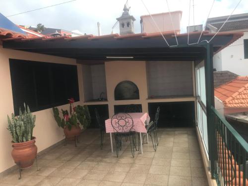 un patio con tavolo e sedie sul balcone. di Estudio Laura a Palmeira