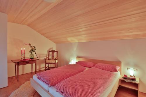 - une chambre avec un lit et un plafond en bois dans l'établissement Haus Elfriede, à Schwarzenberg im Bregenzerwald