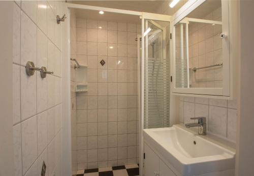 Baño blanco con lavabo y espejo en Wildrijk 152 - Sint Maartenszee, en Sint Maartensvlotbrug