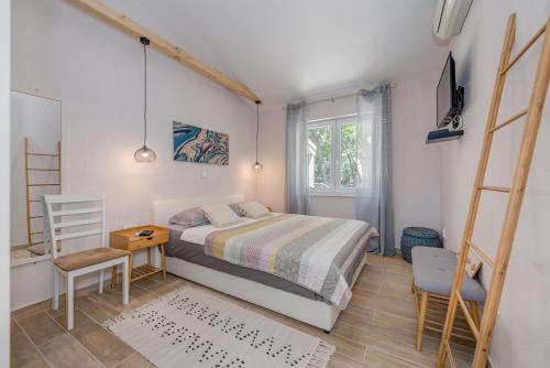 a bedroom with a bed and a desk and a chair at Apartments Jadranka in Mimice