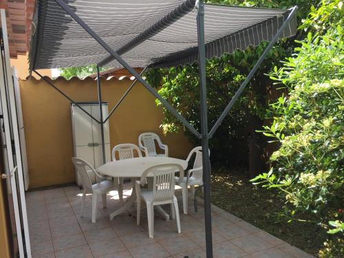 ein Tisch und Stühle unter einem Sonnenschirm auf einer Terrasse in der Unterkunft STUDIO PIED DANS L EAU in La Londe-les-Maures