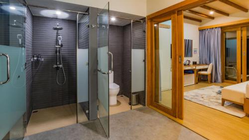 a bathroom with a shower and a toilet at Fiyavalhu Resort Maldives in Mandhoo