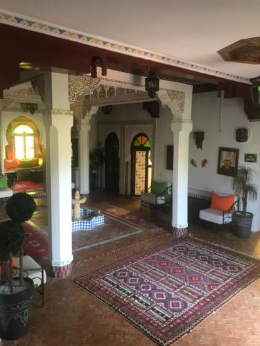 a living room with a rug on the floor at Les Jardins de Ryad Bahia in Meknès