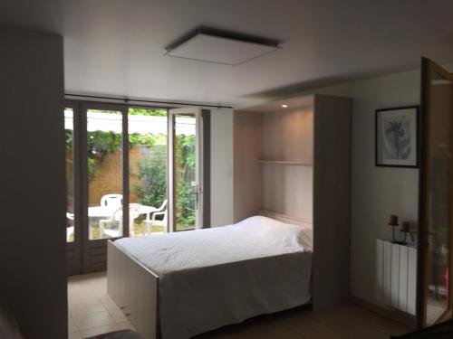a bedroom with a bed and a balcony with a table at STUDIO PIED DANS L EAU in La Londe-les-Maures