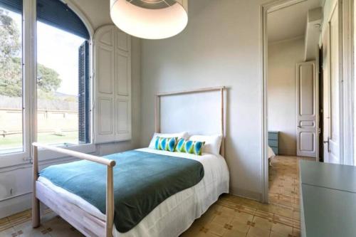 ein Schlafzimmer mit einem Bett und einem großen Fenster in der Unterkunft Casa Mariel in Masnou