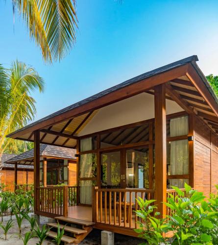 a house on the beach with a large deck at Fiyavalhu Resort Maldives in Mandhoo