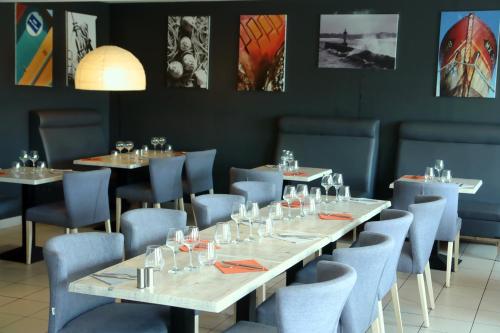 une salle à manger avec des tables et des chaises bleues dans l'établissement La Marine, à Sibiril