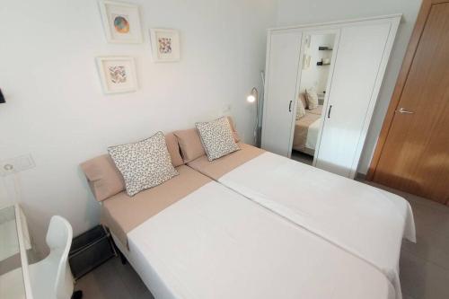 a bedroom with a large white bed in a room at APARTAMENTO PLAYA CATEDRALES CON TERRAZA in Barreiros