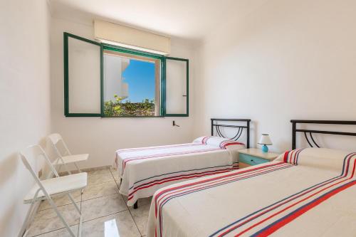 - une chambre avec 3 lits, une fenêtre et une chaise dans l'établissement Villa Vival by BarbarHouse, à Campomarino