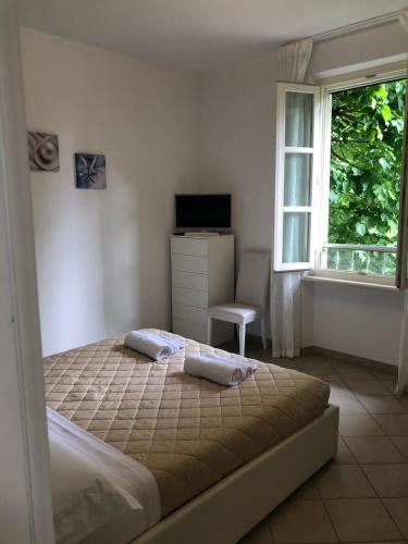 a bedroom with a bed and a window at Acquamarina in Forte dei Marmi