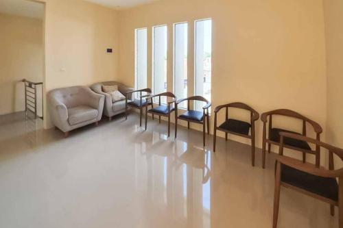 sala de estar con sillas y sofá en Jatiwangi Syariah Guest House Mitra RedDoorz en Majalengka