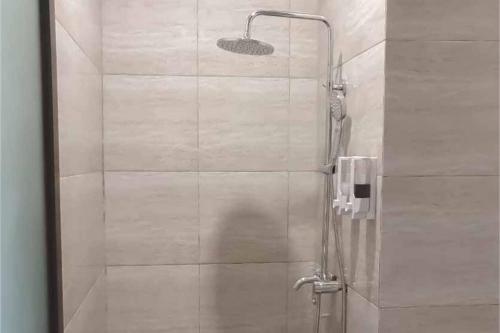 y baño con ducha y puerta de cristal. en Jatiwangi Syariah Guest House Mitra RedDoorz en Majalengka